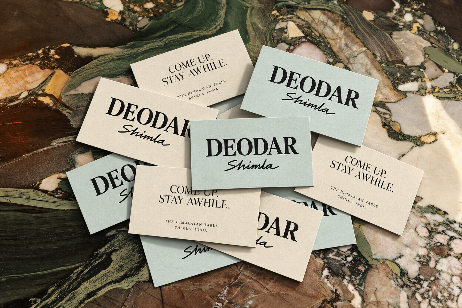 Parchment and mist-coloured Deodar calling cards scattered across richly veined marble