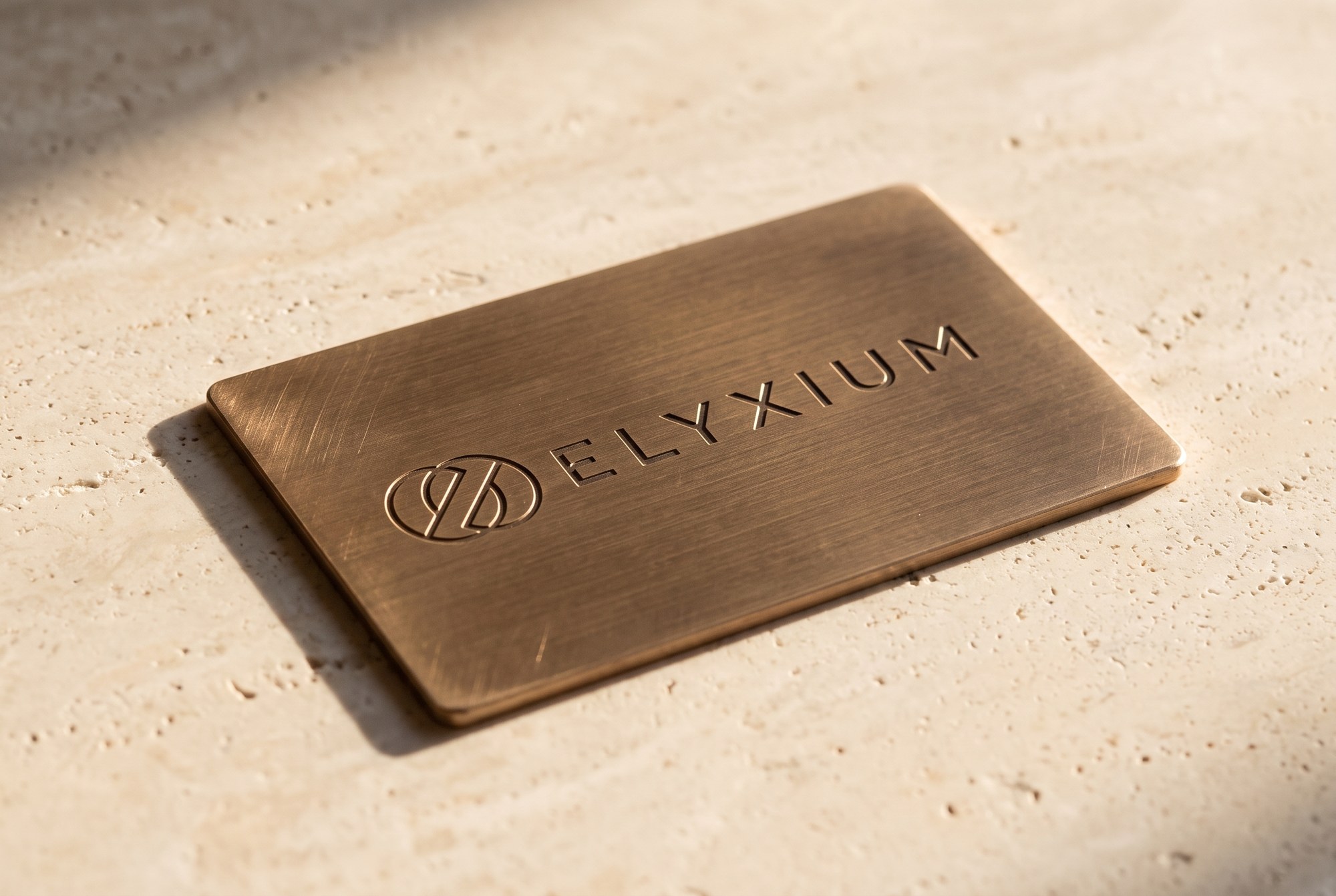 Elyxium wordmark embossed into a brushed bronze card